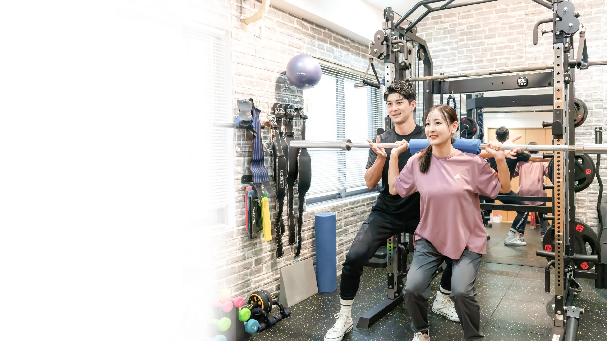 Brightenパーソナルジムでトレーナーが女性にマンツーマンでトレーニング指導を行っている様子